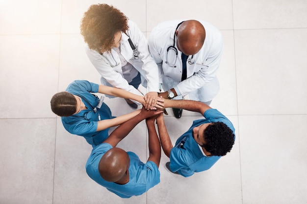 young doctors and surgeons forming huddle right before a surgery operation